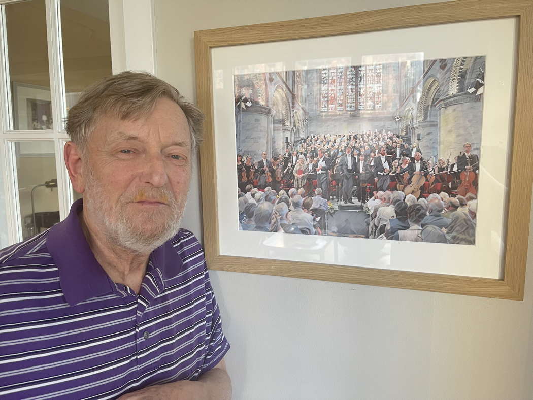 Andrew Davis (1944-2024) at his Chicago home in 2022 with his framed print of Michael Whitefoot's photo from the 2018 Hereford Three Choirs Festival