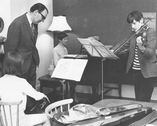 John Joubert with his wife Mary at the piano, his daughter Anna playing cello and his son Pierre on violin at the family home in Moseley, Birmingham, UK