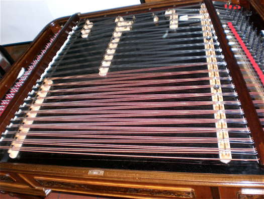 A top view of a modern concert cimbalom, showing the playing area. The strings are struck or plucked.