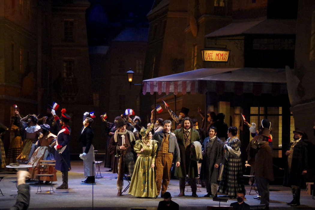 A scene from Act II of 'La bohème' at Teatro Regio Torino, featuring Maria Teresa Leva as Mimi, Iván Ayón Rivas as Rodolfo, Hasmik Torosyan as Musetta, Massimo Cavalletti as Marcello and Alessio Cacciamani as Colline. Photo © 2021 Ivano Coviello