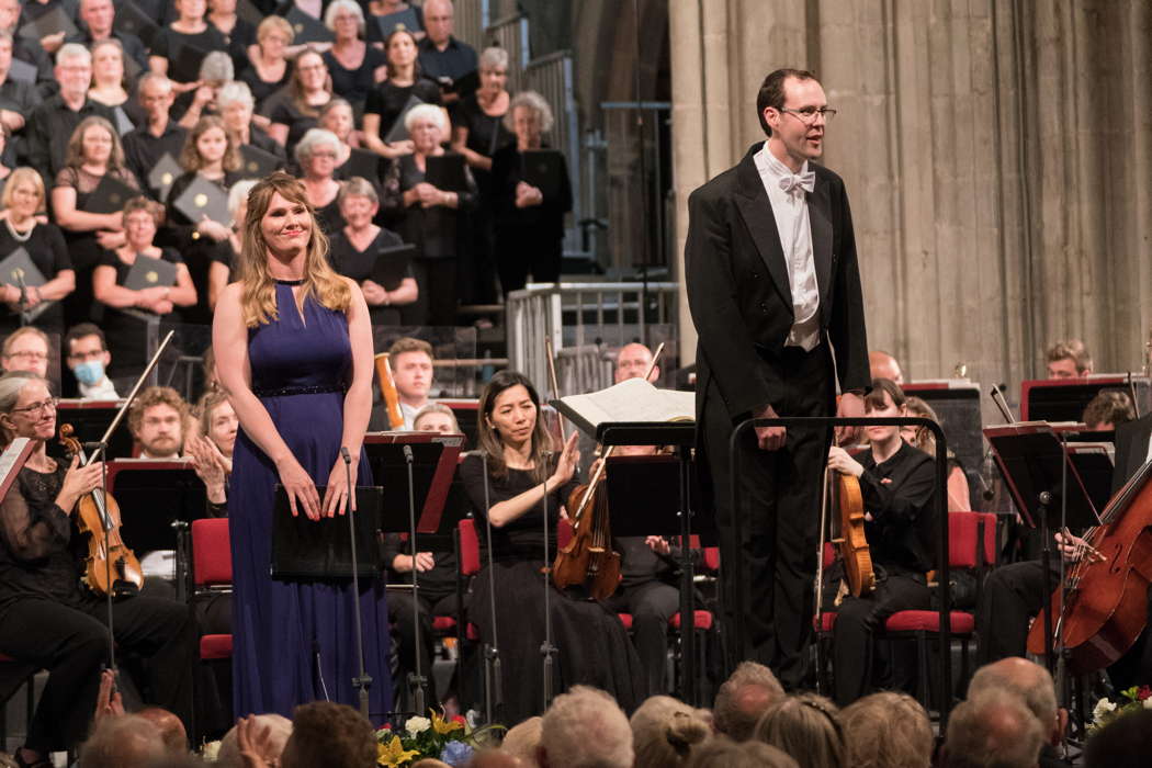 Marta Fontanals-Simmons and Samuel Hudson, acknowledging applause at the end of Elgar's 'The Music Makers', with members of the Philharmonia Orchestra and the Three Choirs Festival Chorus. Photo © 2021 Michael Whitefoot