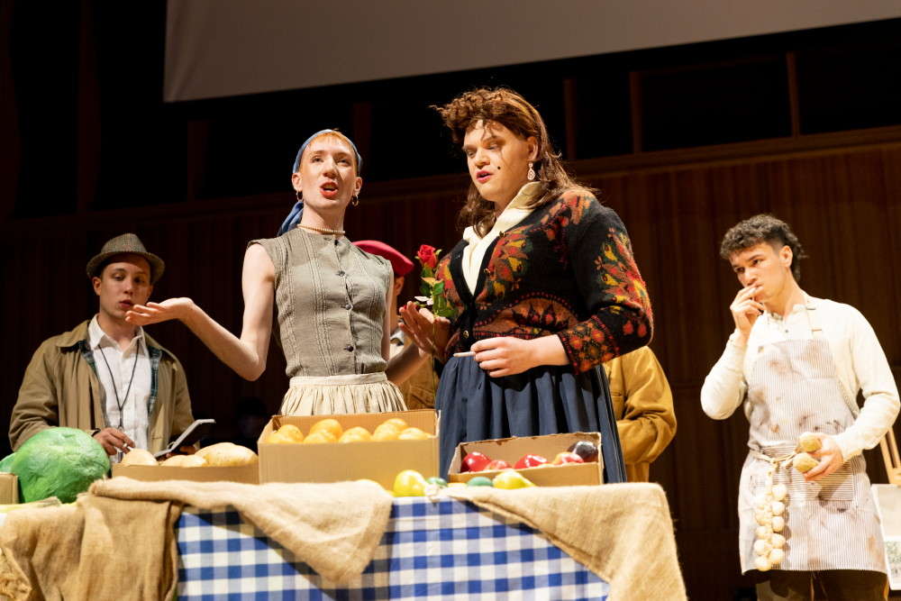 Pushy vegetable seller Oliver Barker (Mme Beurrefondu) prattles away, to the diversion or annoyance of his neighbour Mme Madou (here, Charlie Murray, on right) in Offenbach's 'Mesdames de la Halle'. Photo © 2022 Vitaliy Turovskyy