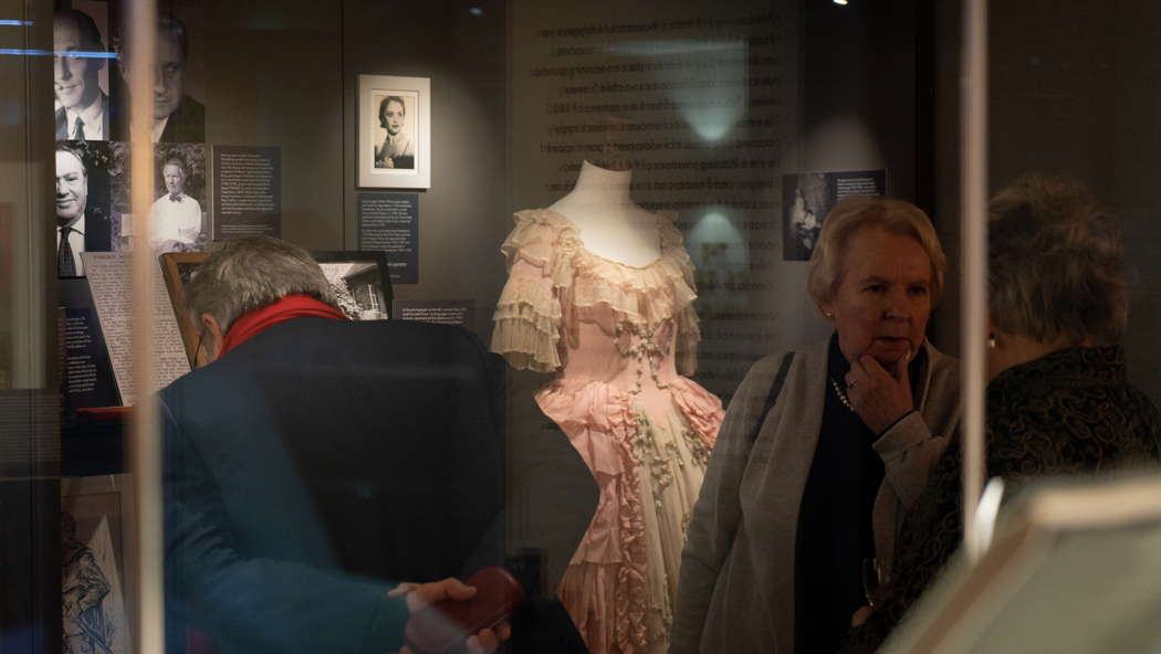 Exhibition visitors in front of a Glyndebourne costume (for Susanna in 'Figaro'), worn by Emigré soprano Irene Eisinger. Photo © 2023 Claire Chevalier