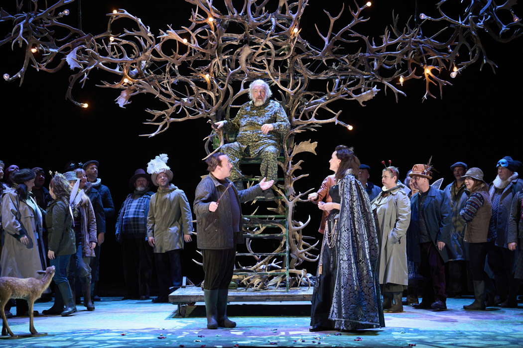 From left to right: Richard Burkhard as Ford, Henry Waddington as Falstaff and Kate Royal as Alice Ford with members of the Chorus of Opera North, in Opera North's production of Verdi's 'Falstaff'. Photo © 2023 Richard H Smith