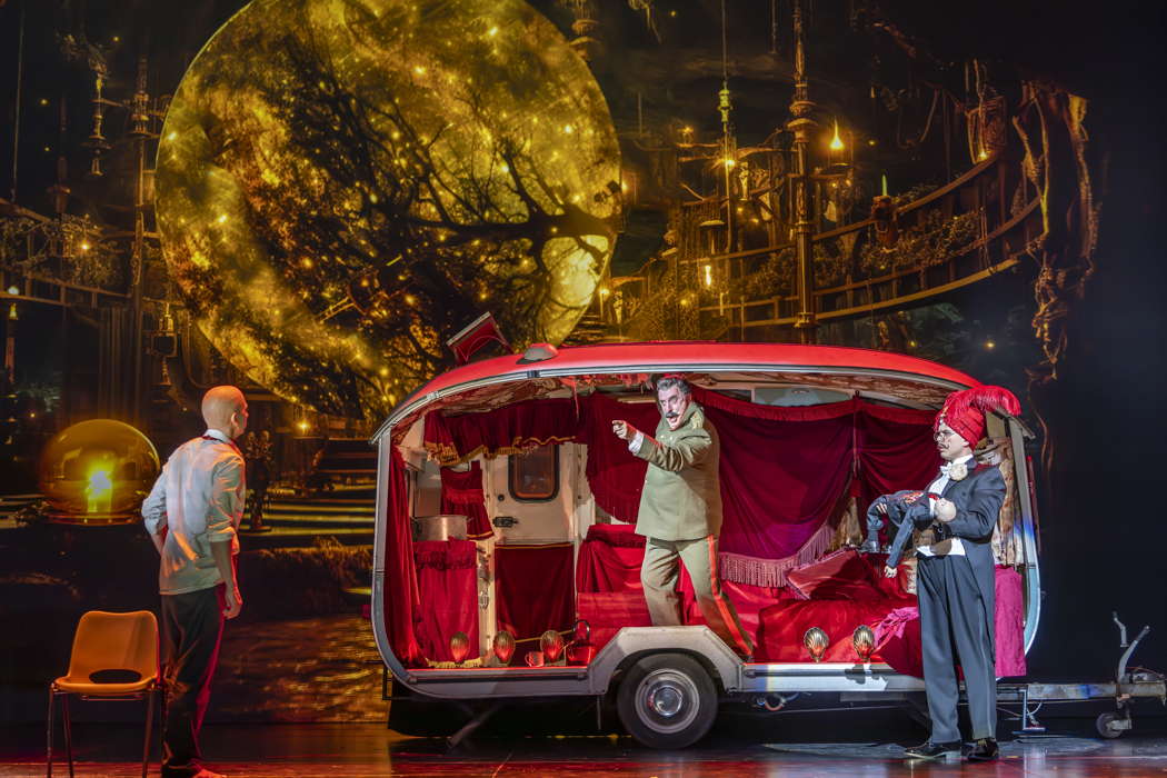 Callum Thorpe as Diktat, left, with Matthew Brook as Samuel in the Witch's caravan and Xavier Hetherington as Seer/Saul. Photo © 2023 James Glossop
