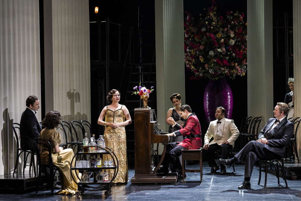 From left to right: Ross McInroy as Périchaud, Laura Kelly-McInroy as Suzy, Galina Averina as Magda, Pasquale Orchard as Yvette, Elgan Llŷr Thomas as Prunier, Satriya Krisna as Gobin, Philip Smith as Rambaldo and Claire Lees as Lisette in Opera North's production of Puccini's 'La Rondine'. Photo © 2023 Tristram Kenton