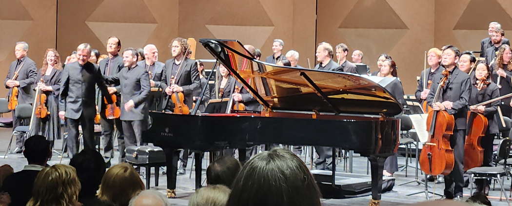 Stephen Hough takes a bow at San Diego Civic Theatre on 16 March 2024, with Lionel Bringuier and members of the San Diego Symphony Orchestra. Photo © 2024 Ron Bierman