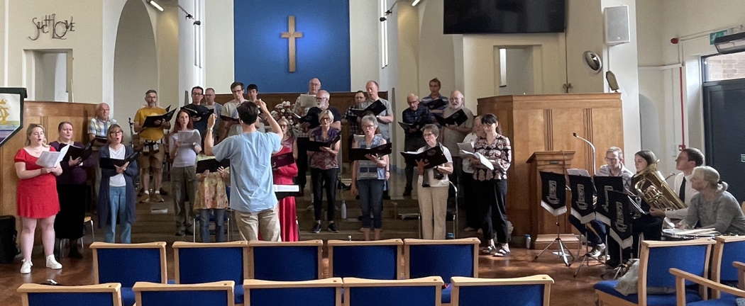 Dexter Drown and the Sitwell Singers rehearsing for their 29 June 2024 concert with, far right, members of Rolls-Royce (Derby) Band