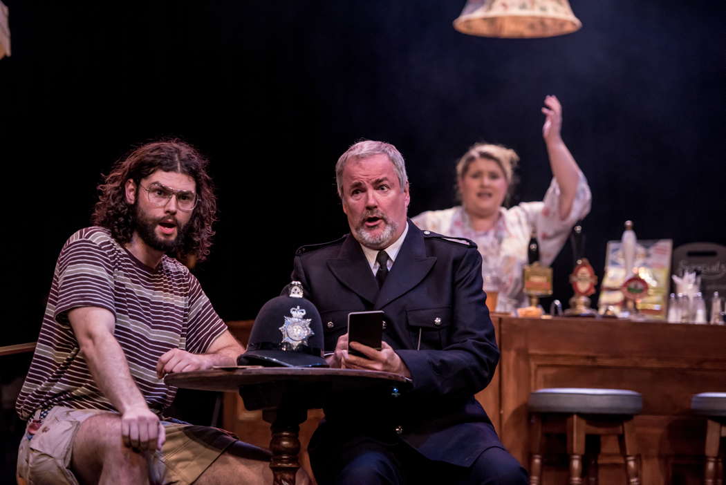 From left to right: Theo Perry as Ned Travers, Richard Woodall as the Policeman and Elizabeth Findon as Mrs Waters in Ethel Smyth's 'The Boatswain's Mate' at the Buxton Festival. Photo © 2024 Genevieve Girling