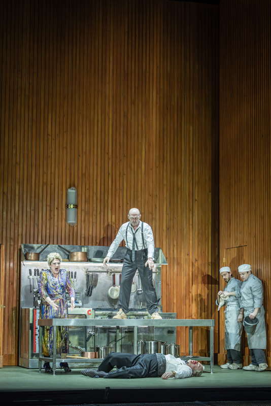 English mezzo Rosie Aldridge as Else (left), Stéphane Degout as Michael (top), who has just physically attacked Gerald Finley as Helge (below) and two members of the cast in the kitchen near the end of 'Festen' at Covent Garden. Photo © 2025 Marc Brenner